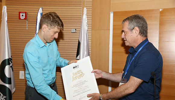 Prof. Moshe Kol hands the prize to Prof. Adam Cohen