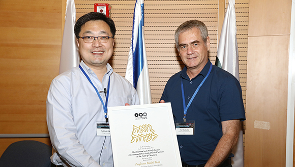 Prof. Moshe Kol hands the prize to Prof. Bozhi Tian